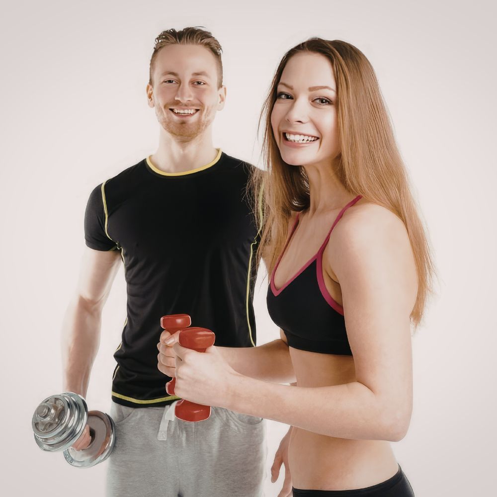 Man and woman holding dumbbells against a plain background
